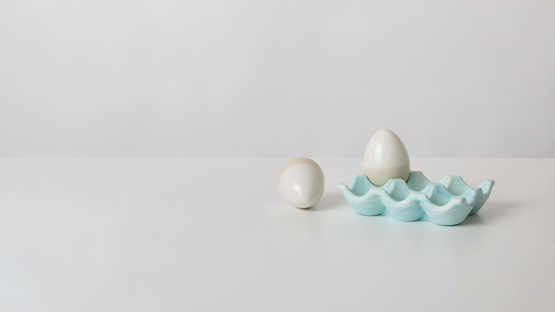 A jesmonite egg holder with two stone eggs
