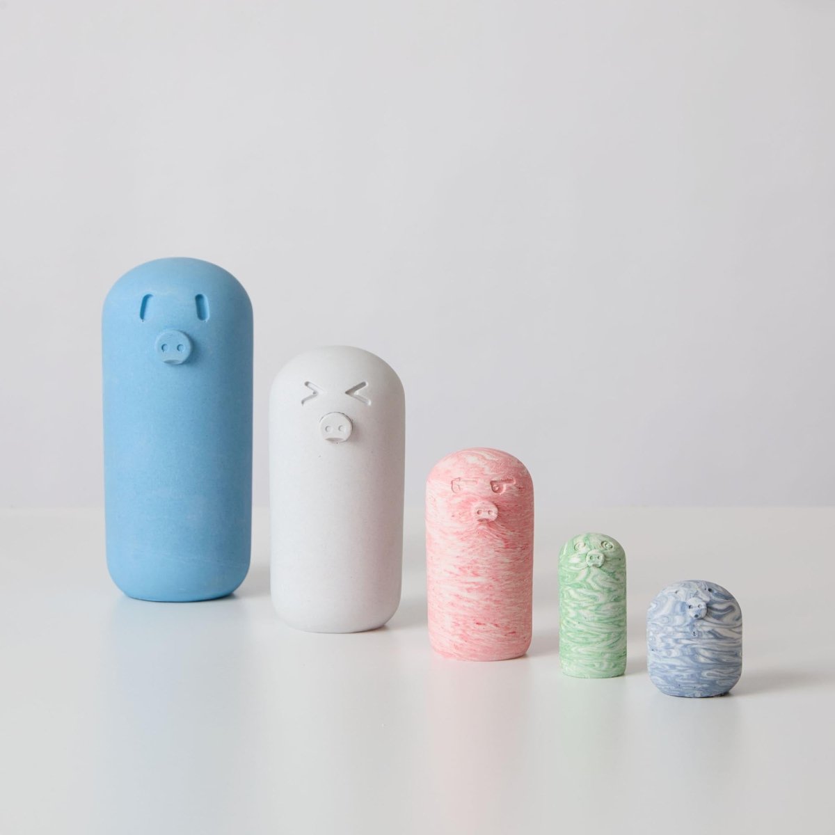 A collection of different sized pig ornaments made from jesmonite a sustainable and eco friendly material for interiors