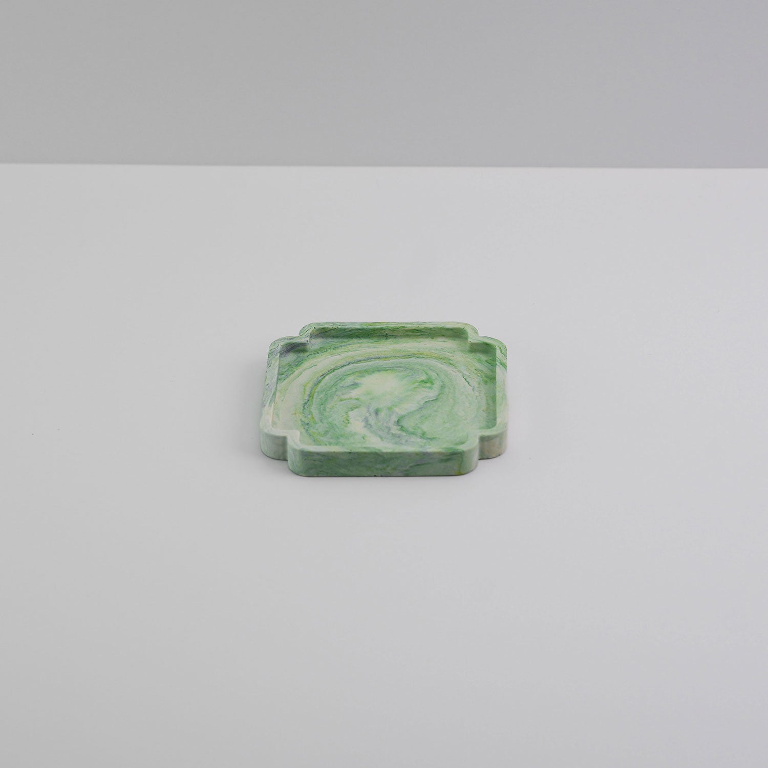 A turquoise and white coaster made from jesmonite a sustainable and eco friendly material for interiors