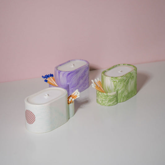 A selection of jesmonite candle holders with matches in various colours. 