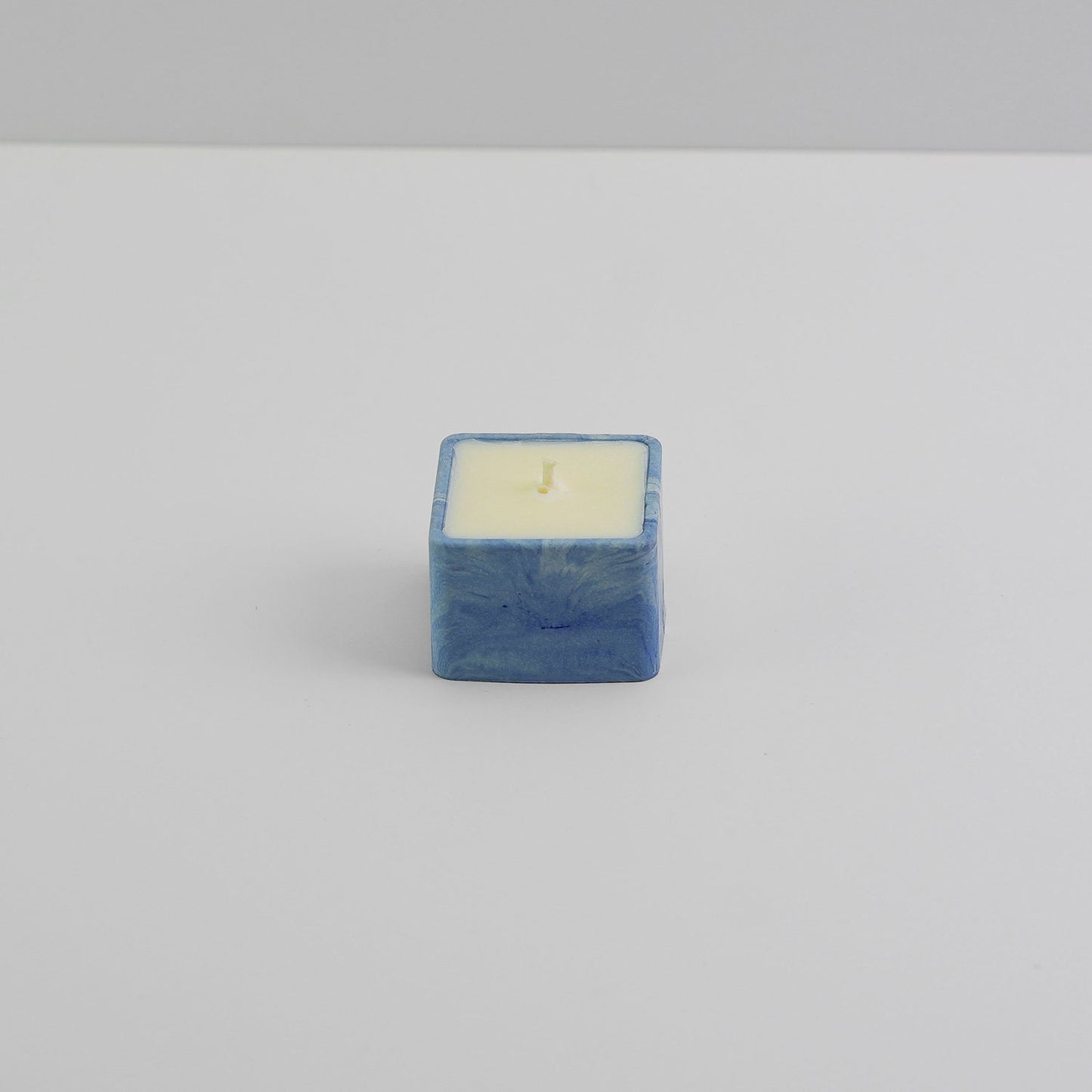 A small, square jesmonite candle holder in blue