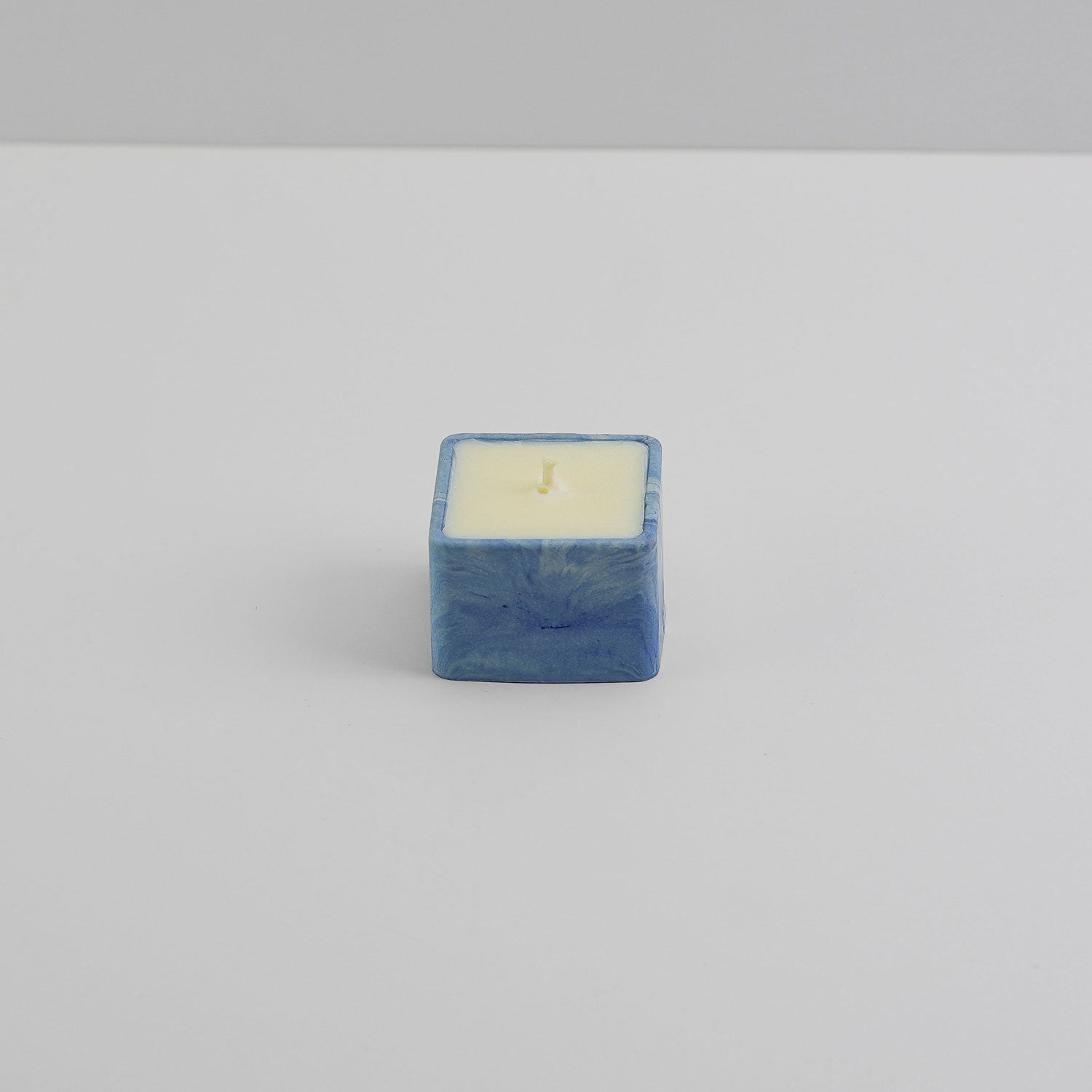 A small, square jesmonite candle holder in blue
