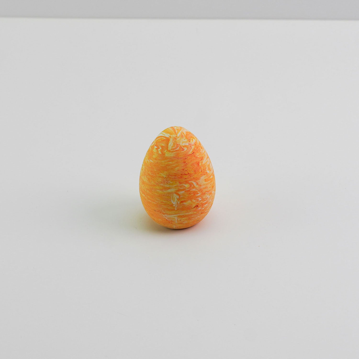 Small Jesmonite decorative egg in a orange tone, suitable for Easter or seasonal styling