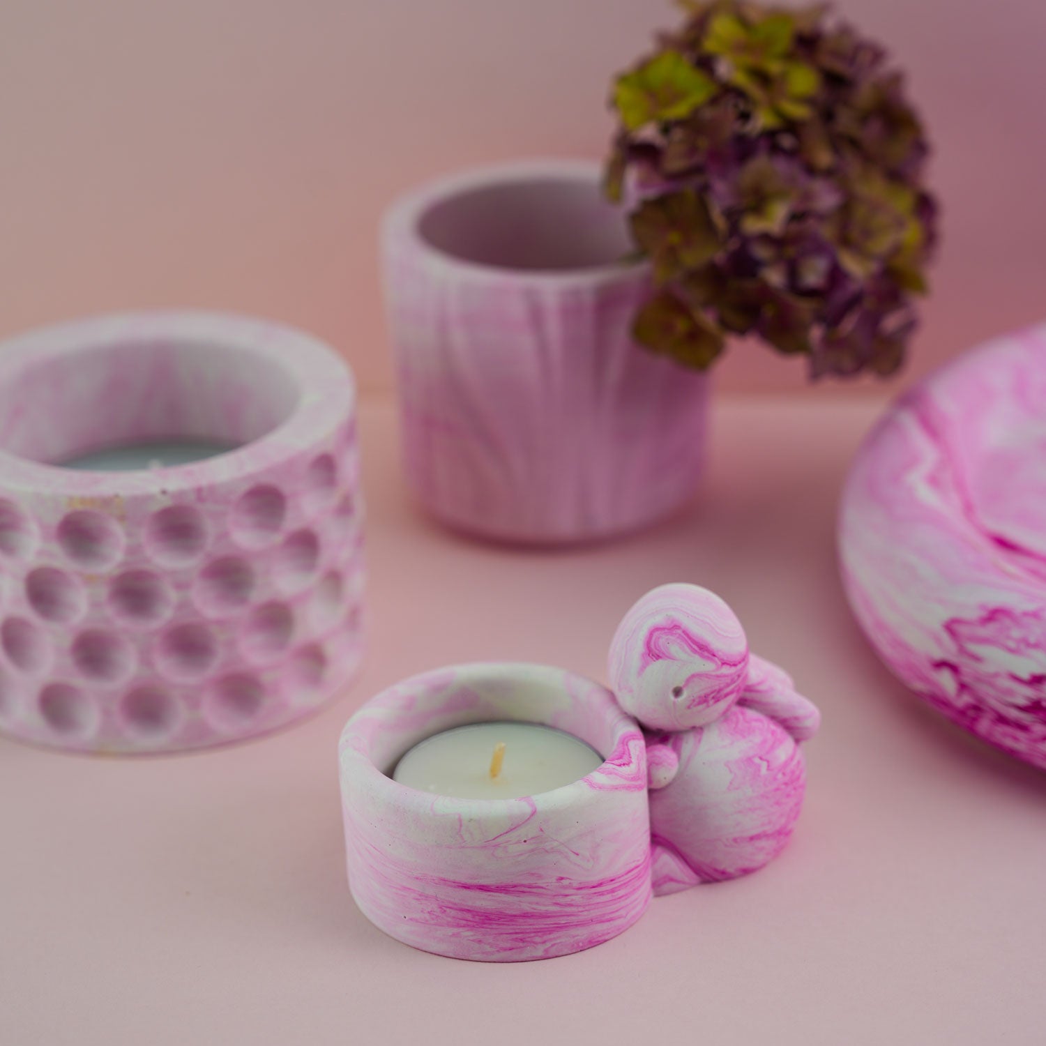 A selection of jesmonite ornaments including a jesmonite bunny candle holder in pink.