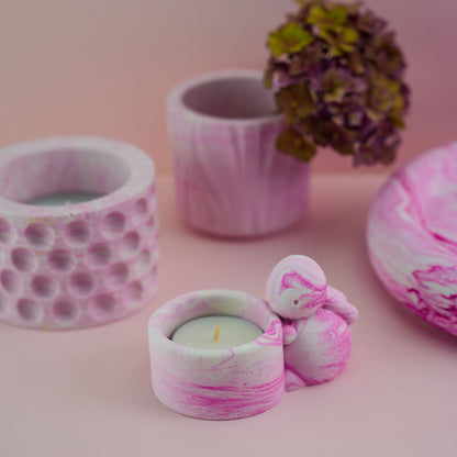 A selection of jesmonite ornaments including a jesmonite bunny candle holder in pink.