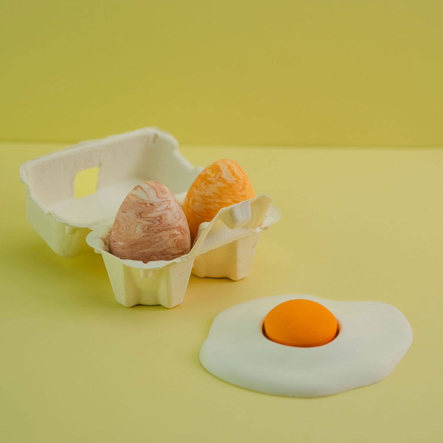 Jesmonite single yolk fried egg and small eggs in carton. 