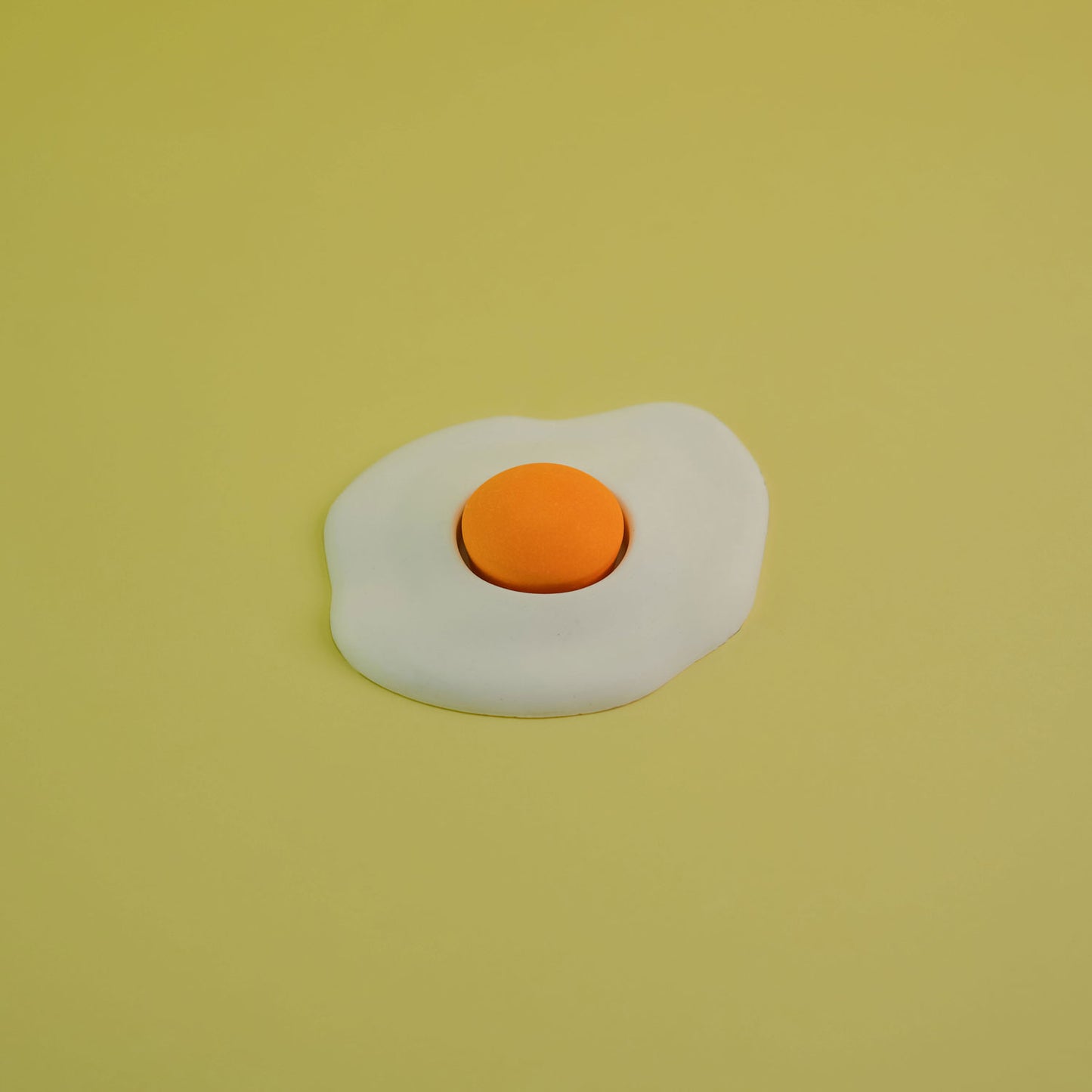 Jesmonite single yolk fried egg in yellow background