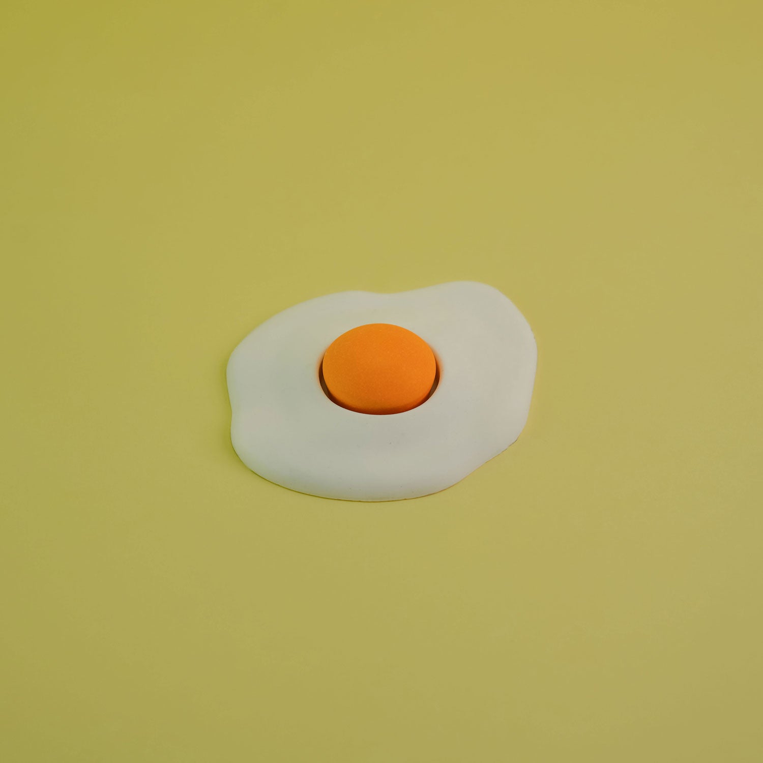 Jesmonite single yolk fried egg in yellow background