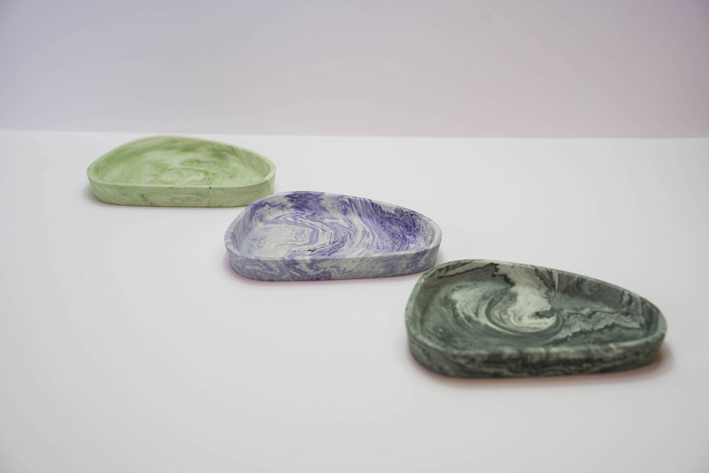 A selection of small Jesmonite trinket trays in a range of colours