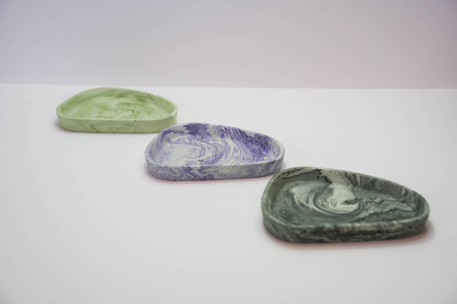 A selection of small Jesmonite trinket trays in a range of colours